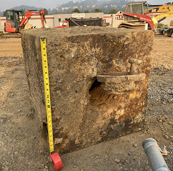 Historic blast safe sitting on the ground, covered in corrosion and dirt