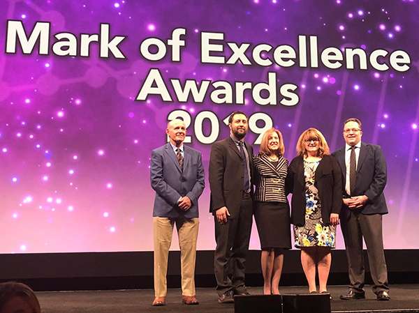 Dr. Emanuele Cauda, second from left, stands on stage