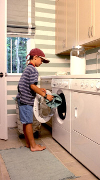young boy doing laundry at home