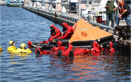 Fishermen in their immersion suits practice life raft entry at Fishermen’s Safety Day in Seattle, WA