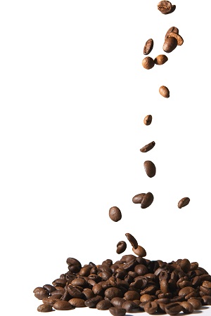 Coffee beans falling into pile isolated on white