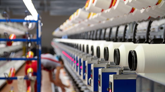 Textile manufacturing plant with worker in background.