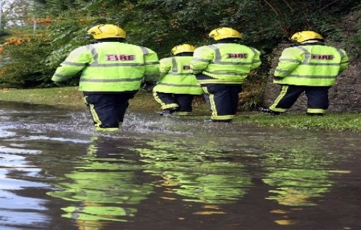 Fire workers walking thru flooded area