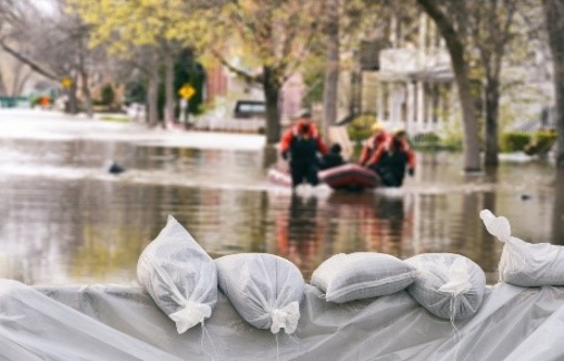 Looking over sand bags at EMS workers dragging a raft