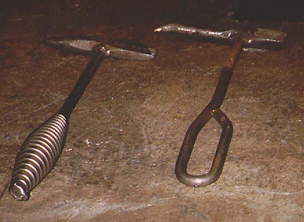 A coiled-handled hammer on left and a loop-handle hammer on right