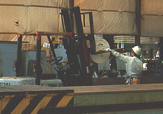 Worker using a a forklift to move cable spool