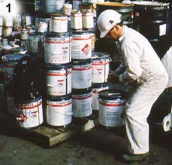 Worker lifting paint cans stacked on pallet