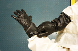 Worker putting on gloves made of butyl rubber.