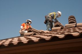 two men working on top of a roof