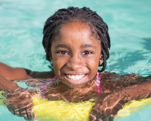 girl swimming with life saver looking into camera