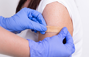 Patient receiving band-aid after vaccination