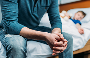 man with hands together on kids bed