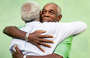 Older business casual professionals hugging