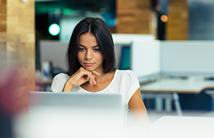 portrait of surious business woman using laptop in office