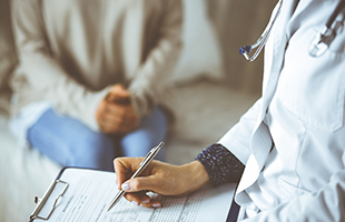 dr charting while patient sitting in background