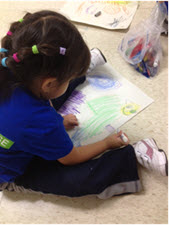 Child sitting on the floor coloring