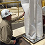 Eric Esswein of the CDC National Institute of Safety %26amp; Health (NIOSH) is shown next to the mini baghouse technology he designed to reduce worker exposure to silica dust at hydraulic fracturing sites.