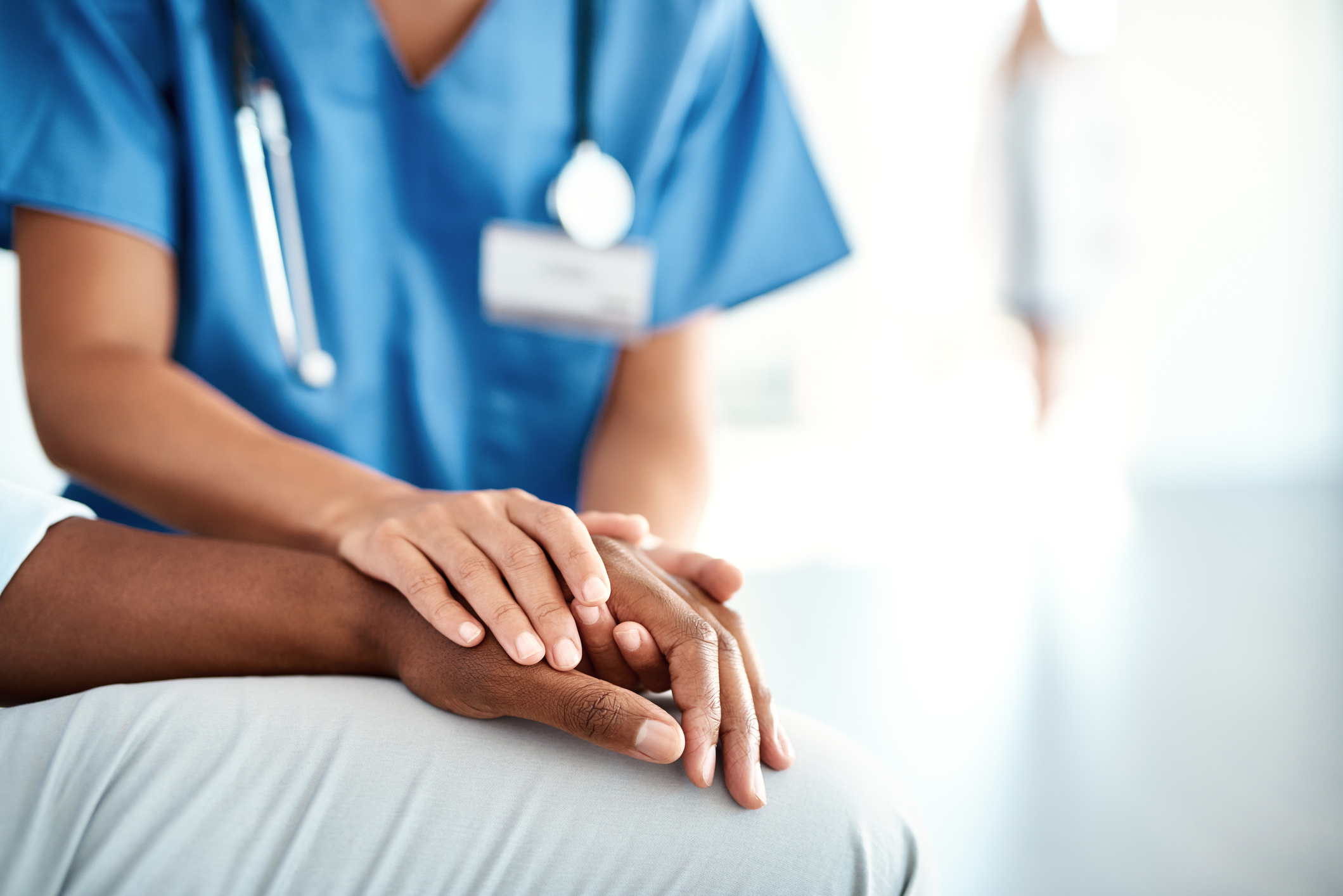 photo of doctor holding patients hand