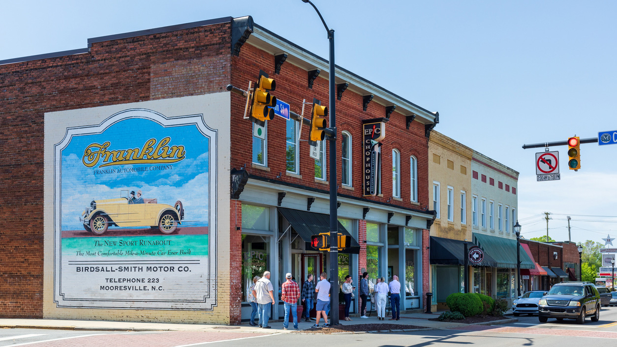 A smalltown downtown showing old store fronts and people.
