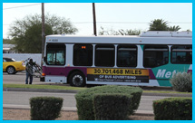 Photo of resident placing his bike on the front of a mass transit bus.