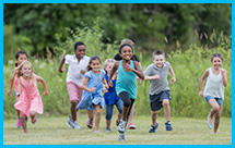 Many elementary school children run together in a field.