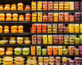 Photo of packages of pre-cut melon on shelves.