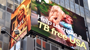 Kate O’Brien and her son Jimmy on the NYC Times Square Jumbotron. Space secured by NTCA.