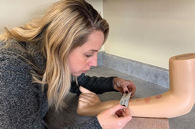 Rebecca Kishlock, Interim Executive Director measuring readings on the educational TB arms