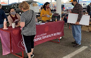 Community health workers at a flea market registering people for vaccination.