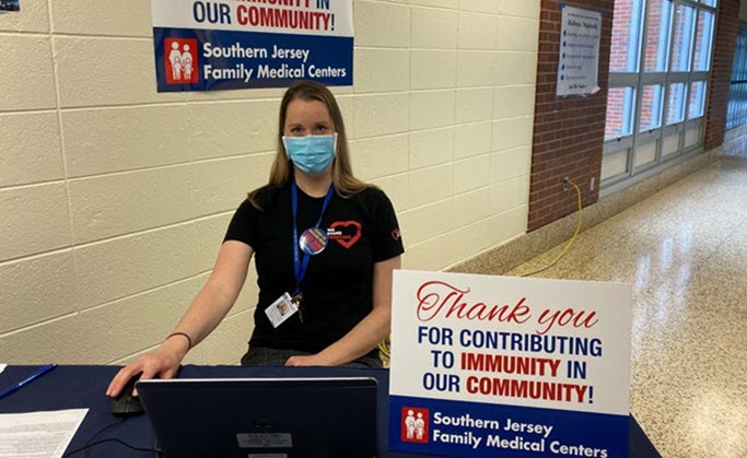 nurse in a mask registers people for COVID-19 vaccinations.