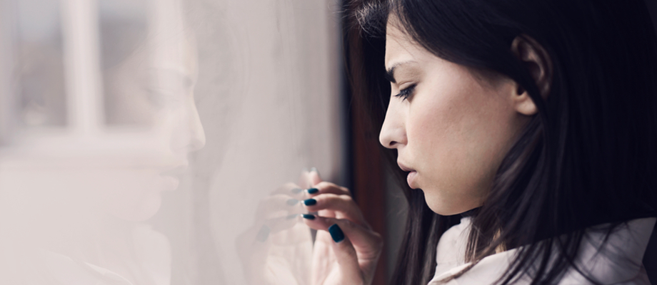 Depressed woman looking out of window