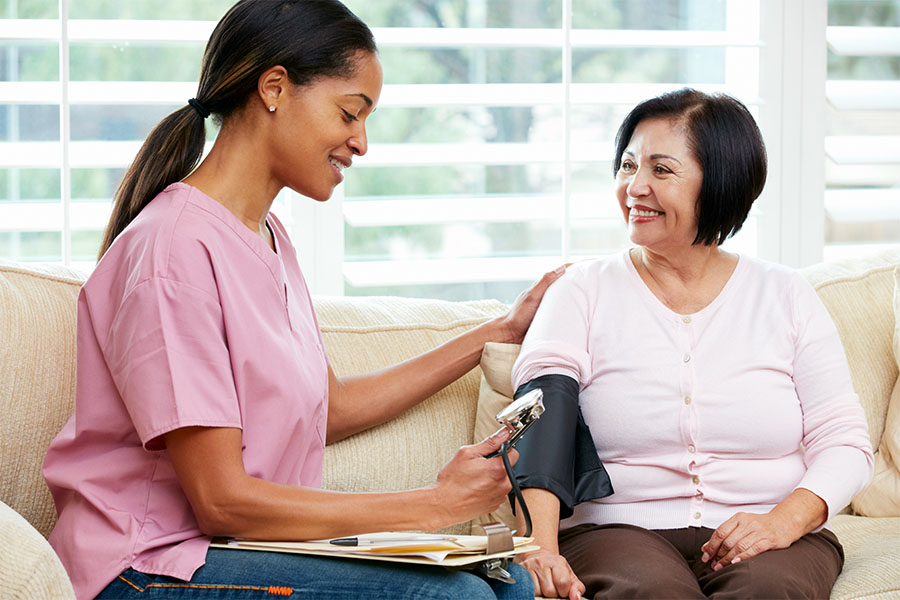 Young nurse making a home visit to a female senior patient.