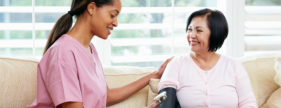 Young nurse making a home visit to a female senior patient.