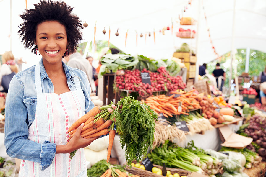 Female Stall Holder At Farmers Fresh Food Market.